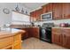 Functional kitchen with dark cabinets, and black appliances at 44250 W Vineyard St, Maricopa, AZ 85139