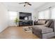 Cozy living room featuring tile floors, a modern entertainment center, and comfortable seating at 44250 W Vineyard St, Maricopa, AZ 85139