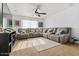 Spacious living room with comfortable gray sectional sofa, carpet, and natural light at 44250 W Vineyard St, Maricopa, AZ 85139