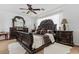 Spacious main bedroom featuring an ornate bed, accent pillows, and a ceiling fan at 44250 W Vineyard St, Maricopa, AZ 85139
