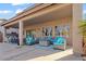 Covered patio featuring ample seating and dining space with a brightly-colored outdoor rug at 44250 W Vineyard St, Maricopa, AZ 85139