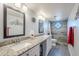 Updated bathroom with dual sinks, granite countertop, decorative mirror and tiled walk-in shower at 5507 E Grandview Rd, Scottsdale, AZ 85254