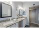 Bathroom featuring dual sinks with granite counters, tile floors, and a glass-door shower at 5507 E Grandview Rd, Scottsdale, AZ 85254