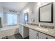 Bright bathroom with dual sinks, granite countertops, and a garden tub with window at 5507 E Grandview Rd, Scottsdale, AZ 85254