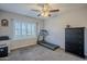 Bright bedroom with a ceiling fan, white shutters, and exercise equipment at 5507 E Grandview Rd, Scottsdale, AZ 85254