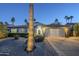 Inviting single-Gathering home with a lush front yard, palm trees, a well-lit entrance, and a convenient two-car garage at 5507 E Grandview Rd, Scottsdale, AZ 85254