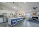 Bright open kitchen with stainless appliances, white cabinetry, pendant lights and island with seating, flowing into the living space at 5507 E Grandview Rd, Scottsdale, AZ 85254