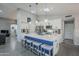 Bright open kitchen with stainless appliances, white cabinetry, pendant lights and large island with seating, opening to living space at 5507 E Grandview Rd, Scottsdale, AZ 85254
