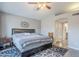 Main bedroom with en suite bathroom access, ceiling fan, and a dark wood bed frame at 5507 E Grandview Rd, Scottsdale, AZ 85254