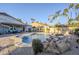 Beautiful backyard pool with rock waterfall feature, surrounded by desert landscaping and palm trees at 5507 E Grandview Rd, Scottsdale, AZ 85254