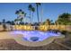 Sparkling backyard pool with a unique design, rock features, and lush desert landscaping at 5507 E Grandview Rd, Scottsdale, AZ 85254