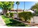 View of the fenced community pool area, with palm trees and manicured green spaces, from outside at 5995 N 78Th St # 2030, Scottsdale, AZ 85250