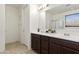 Bright bathroom features a double sink vanity with dark wood cabinets and a large mirror at 676 N 156Th Ln, Goodyear, AZ 85338