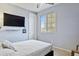 Cozy bedroom with light gray walls, a comfortable bed, natural light, and hardwood floors at 676 N 156Th Ln, Goodyear, AZ 85338