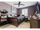 Cozy bedroom with a dark wood bed frame, ceiling fan, and a window with natural light at 676 N 156Th Ln, Goodyear, AZ 85338