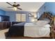 Spacious bedroom with a king-size bed, ceiling fan, and a mounted television at 676 N 156Th Ln, Goodyear, AZ 85338