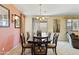 Warm dining room with a wood table, six chairs, chandelier, and sliding door access to the patio at 676 N 156Th Ln, Goodyear, AZ 85338