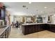 Expansive kitchen featuring a large island, dark wood cabinets, and open layout to the dining area at 676 N 156Th Ln, Goodyear, AZ 85338