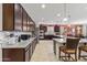A spacious kitchen featuring granite countertops, dark cabinets, and stainless steel appliances at 676 N 156Th Ln, Goodyear, AZ 85338