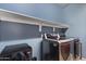 Functional laundry room with modern washer and dryer, ample shelving for storage and organization at 676 N 156Th Ln, Goodyear, AZ 85338