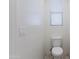 Small, all-white water closet with a toilet and a window with blinds at 676 N 156Th Ln, Goodyear, AZ 85338