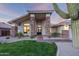 Inviting home exterior with stone accents, a well-manicured lawn, and desert landscaping at 8900 E Palm Tree Dr, Scottsdale, AZ 85255