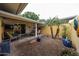 Cozy back patio with desert landscaping, covered area with chairs, and sliding glass doors to interior at 10407 N 108Th Ave, Sun City, AZ 85351