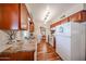 Well-lit kitchen with wood cabinets, a white refrigerator, and modern appliances at 10407 N 108Th Ave, Sun City, AZ 85351