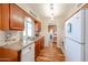 Bright kitchen with stainless steel sink, wood cabinets, modern appliances, and wood flooring at 10407 N 108Th Ave, Sun City, AZ 85351