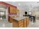 Open kitchen with island, wood cabinets, and views into the dining area at 1179 E Coyote Creek Way, San Tan Valley, AZ 85143