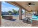 Covered patio with ceiling fans and comfortable seating overlooking the pool at 1179 E Coyote Creek Way, San Tan Valley, AZ 85143