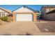 The garage features a white door and a spacious driveway, surrounded by landscaping stones and low-maintenance greenery at 1240 W Straford Dr, Chandler, AZ 85224