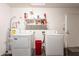 Bright laundry room featuring washer, dryer, water heater, shelving and a red bin at 1240 W Straford Dr, Chandler, AZ 85224