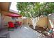 Charming patio with a red umbrella, outdoor seating, and a decorative orange tree at 13861 N 111Th Ave, Sun City, AZ 85351