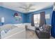 Cozy bedroom with blue walls, a ceiling fan, white trim, chair, and a white crib at 16302 N 36Th Ave, Phoenix, AZ 85053