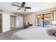 Bright bedroom with a ceiling fan features a large window and sliding doors to the backyard at 16302 N 36Th Ave, Phoenix, AZ 85053