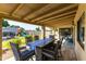 Covered patio with table and chairs with views of the pool, play structure, and nicely landscaped backyard at 16302 N 36Th Ave, Phoenix, AZ 85053