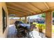 A covered outdoor patio with a dining table and seating that overlooks the backyard at 16302 N 36Th Ave, Phoenix, AZ 85053