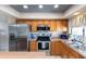 Well-lit kitchen featuring stainless steel appliances, natural wood cabinetry, and decorative tin ceiling at 16302 N 36Th Ave, Phoenix, AZ 85053