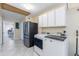 Bright laundry room with stainless steel fridge, washer, dryer, and overhead storage cabinets at 16302 N 36Th Ave, Phoenix, AZ 85053