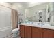 A well-lit bathroom featuring a wooden vanity and a shower/tub combination at 17532 W Bajada Rd, Surprise, AZ 85387