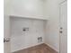 Laundry room with built-in shelving and tile flooring at 201 2Nd E Ave, Buckeye, AZ 85326