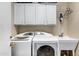 Laundry room with washer, dryer, cabinets, and utility sink at 20208 N Oxbow Ln, Maricopa, AZ 85138