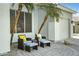 Cozy outdoor patio with wicker furniture and potted palm trees near a three car garage at 2105 N Kachina --, Mesa, AZ 85203