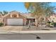 Single-story home with tan exterior, two-car garage, and desert landscaping at 22506 N Mirage Ln, Sun City West, AZ 85375