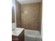 Full bath featuring single sink vanity and shower and tub with brown tile surround at 2324 W Luke Ave, Phoenix, AZ 85015