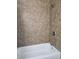 Shower and tub with brown tile surround at 2324 W Luke Ave, Phoenix, AZ 85015