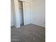 Bedroom featuring neutral carpet, closet with sliding doors, and freshly painted white walls at 2324 W Luke Ave, Phoenix, AZ 85015