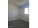 Minimalist bedroom with neutral carpet, white walls, and natural light from a window at 2324 W Luke Ave, Phoenix, AZ 85015