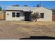 Neutral colored single-level home featuring a secure wood fence and mature shrubbery at 2324 W Luke Ave, Phoenix, AZ 85015